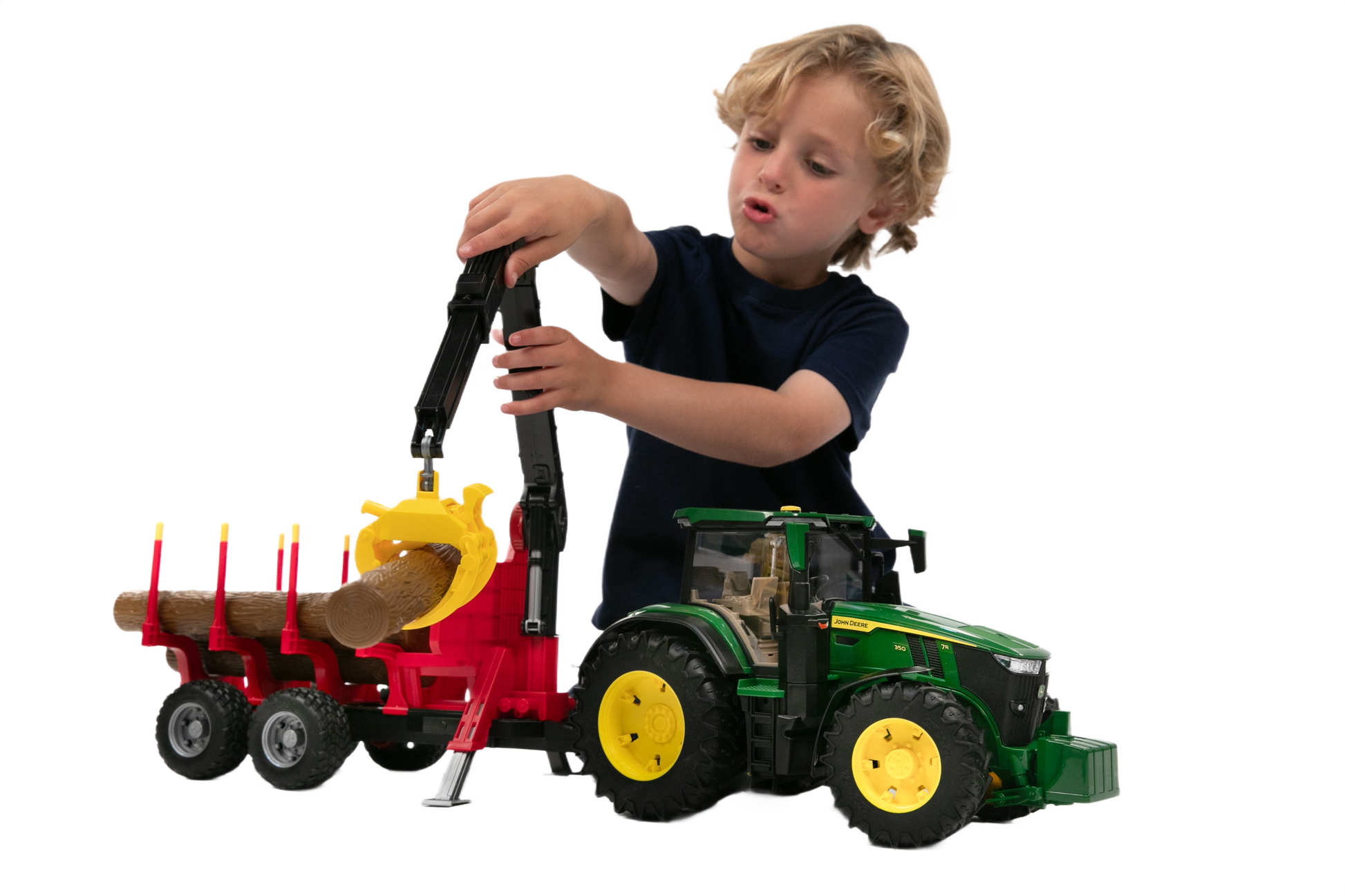 Child playing with green and yellow tractor and red forestry trailer loading wooden logs for imaginative home improvement play