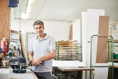 Man using Festool 576577 KA 65 Conturo Edge Bander Only in a woodworking shop with tools and materials nearby