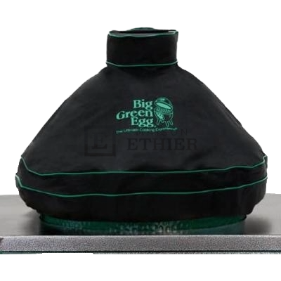 Black waterproof dome cover with green trim protecting a large outdoor grill in a backyard setting