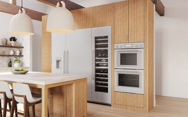 Built-in stainless steel double steam wall oven installed in modern kitchen with wood panel cabinetry and island seating