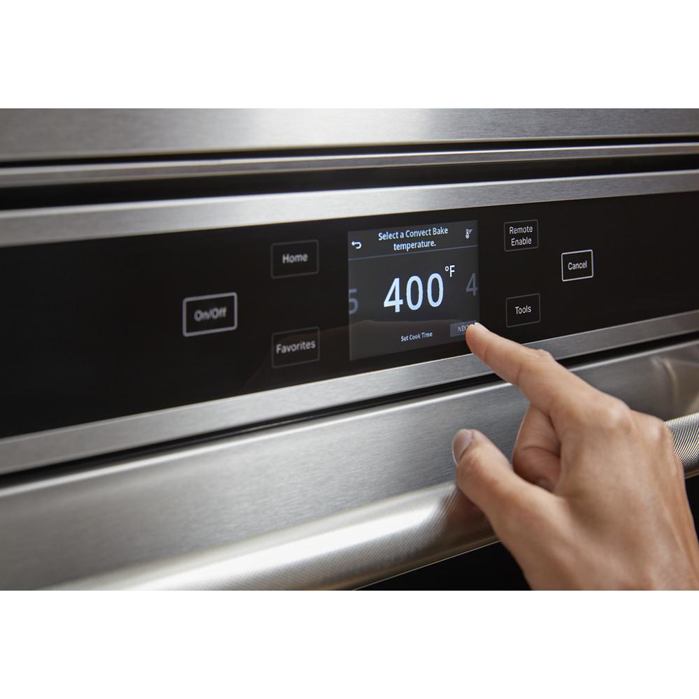Finger selecting 400°F bake temperature on a stainless steel smart wall oven digital control panel