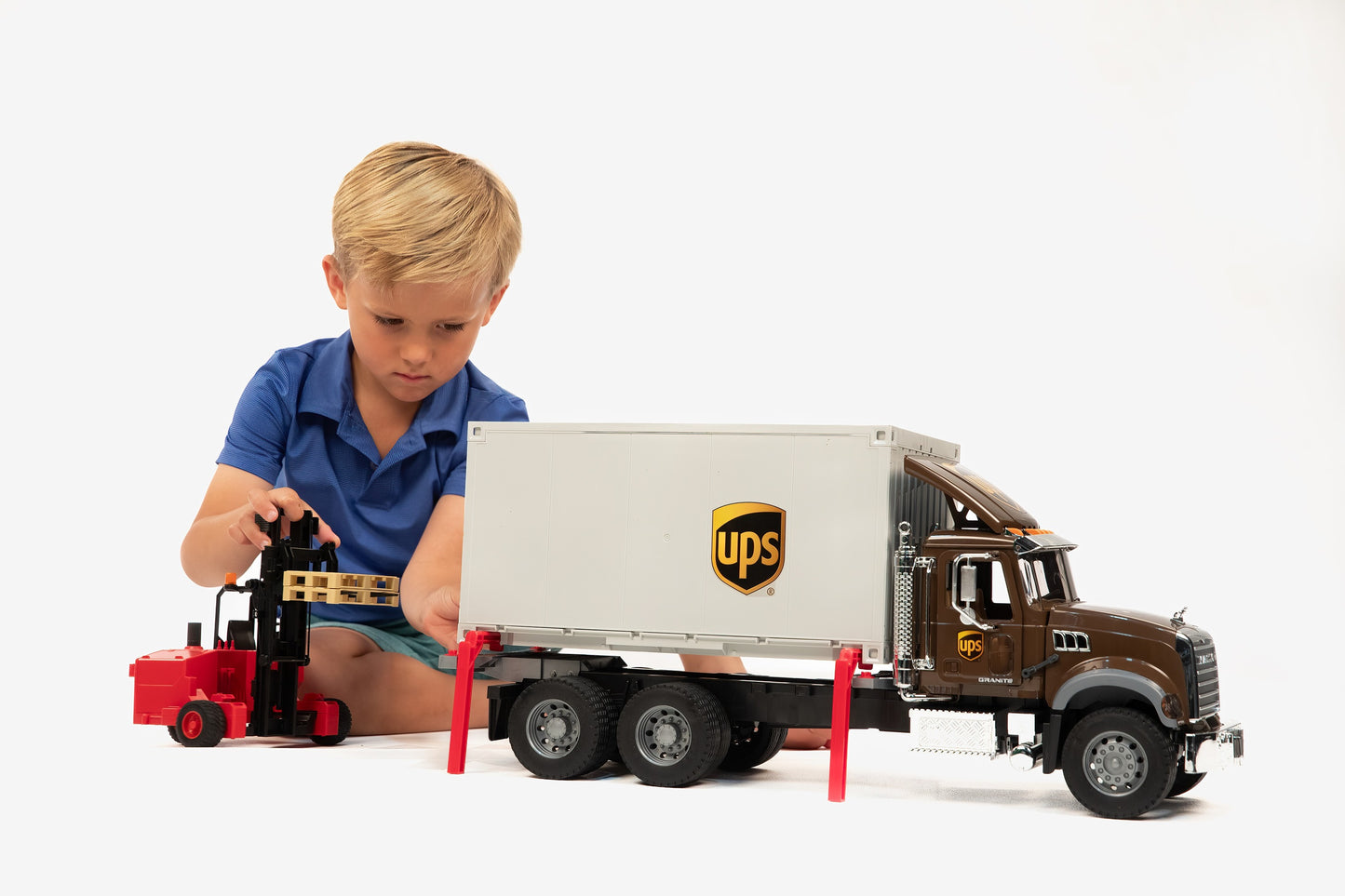 Child playing with detailed brown and white UPS logistics truck and red forklift in Vehicles & Remote Controlled Toys collection