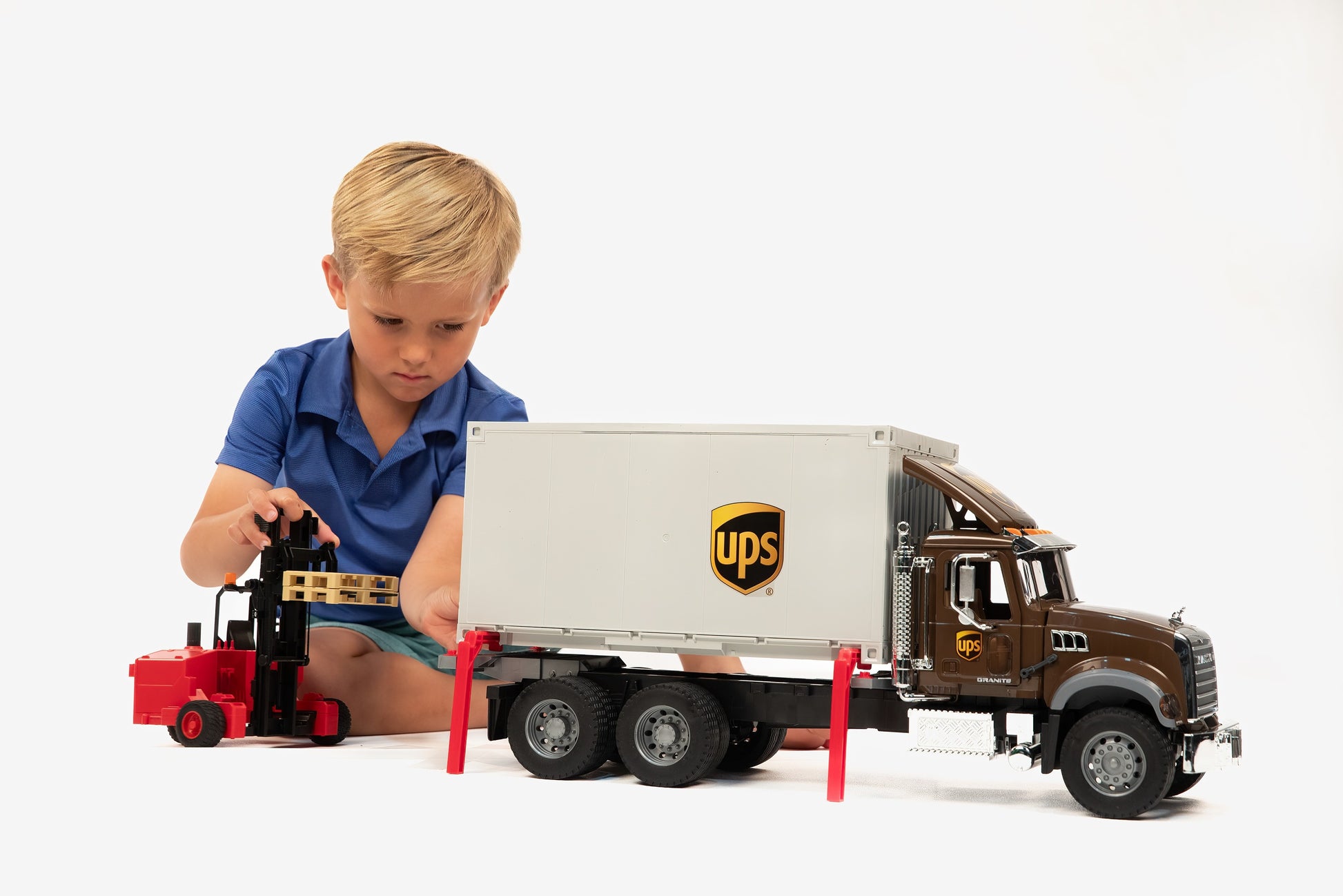 Child playing with detailed brown and white UPS logistics truck and red forklift in Vehicles & Remote Controlled Toys collection