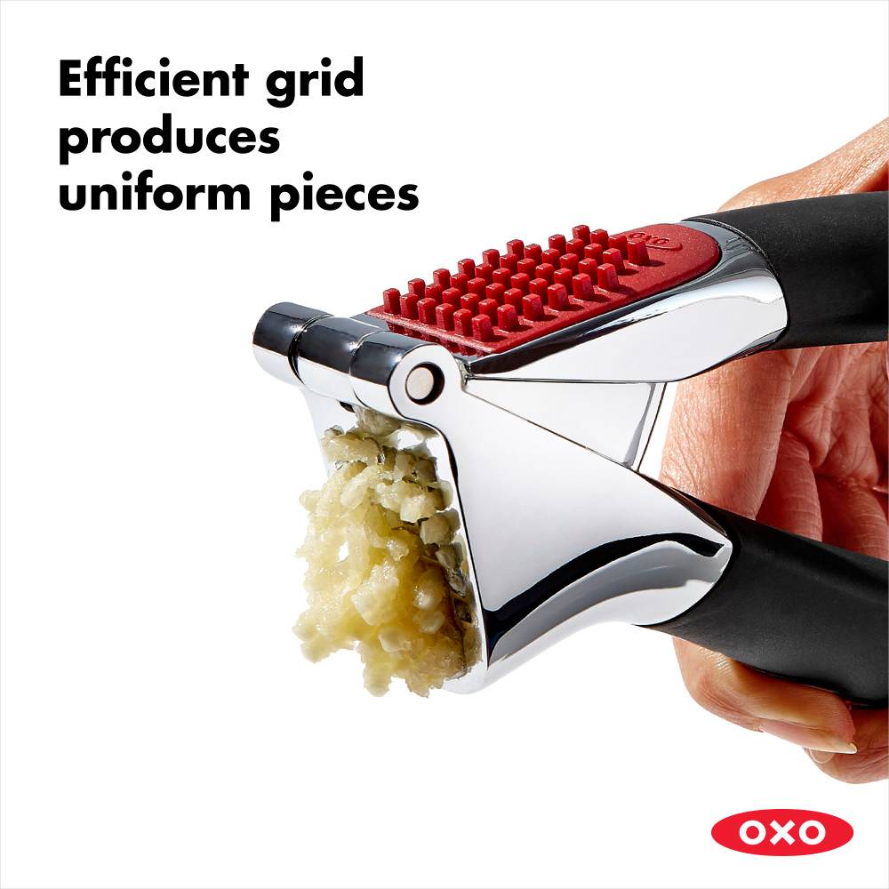 Metal garlic press with red grid and black handles crushing garlic for kitchenware under $50 collections