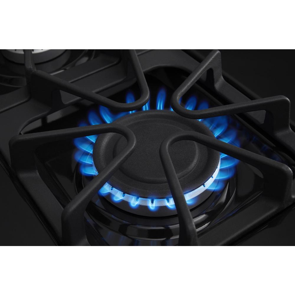 Close-up of blue flame burning on black gas burner grate from range appliance in kitchen collection