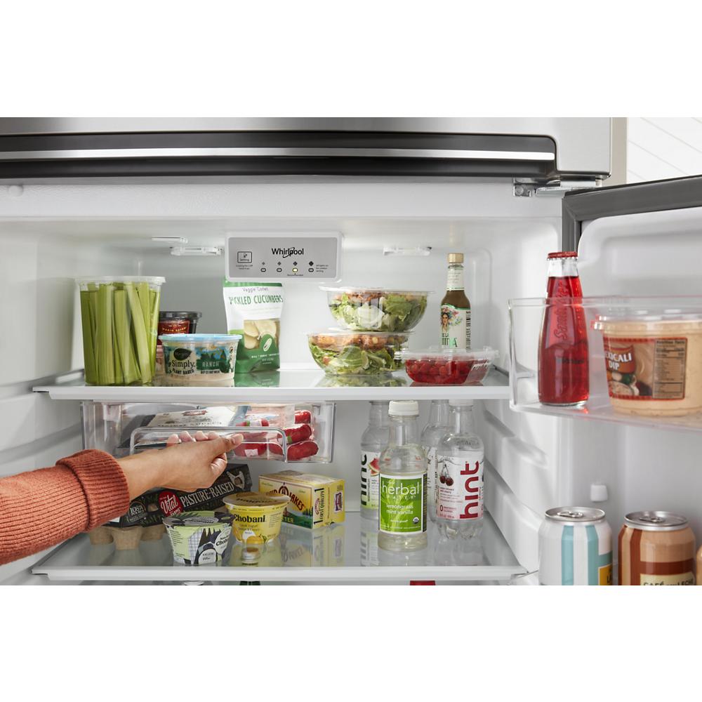 Interior view of Whirlpool top freezer refrigerator with food storage and a hand reaching for items in Refrigerators and Kitchen & Kitchenware collections