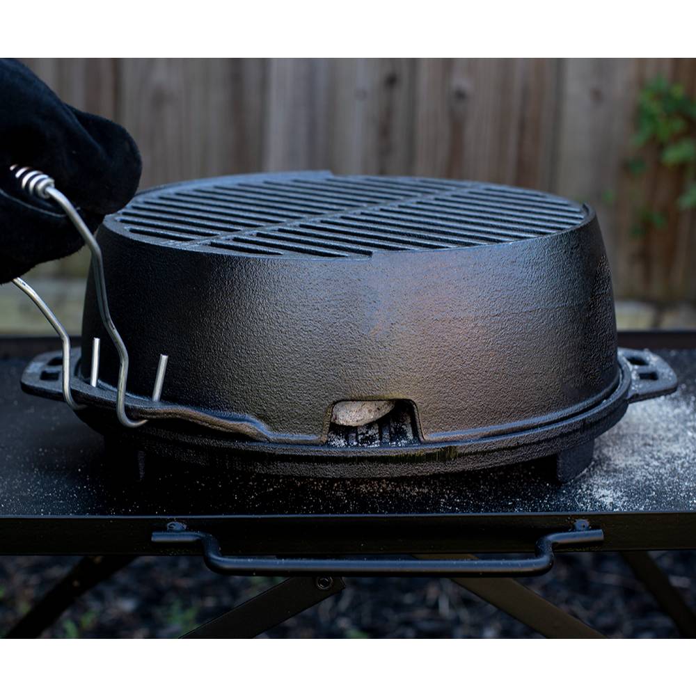 Lodge cast iron grill with detachable handle being lifted on outdoor table in kitchenware collection under $100