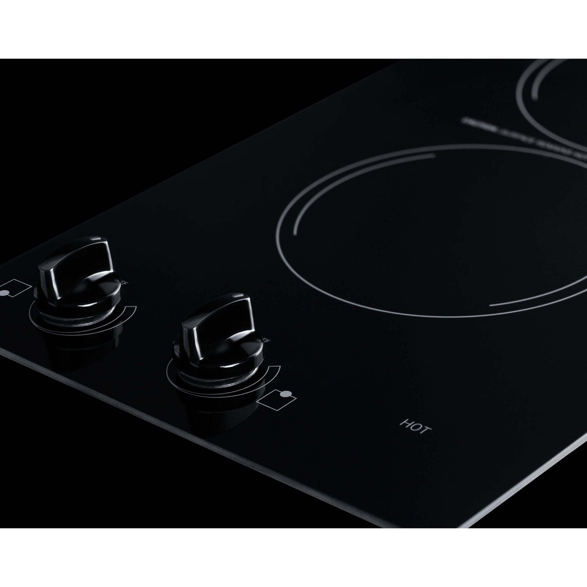 Close-up of black ceramic glass electric cooktop with two control knobs for kitchen appliance installation