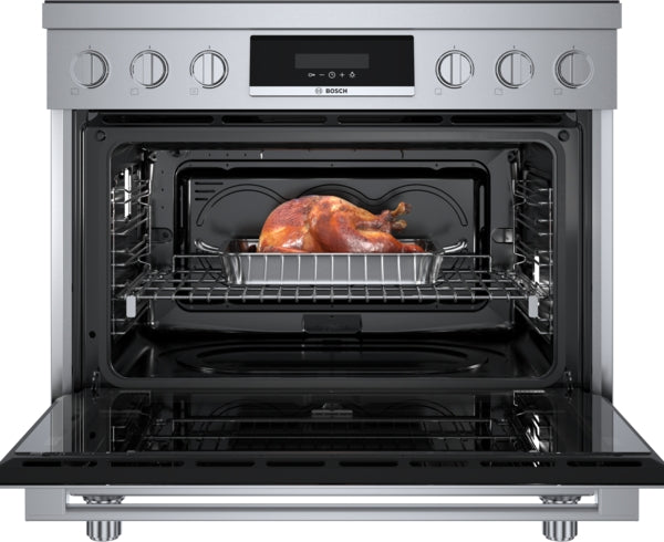 stainless steel induction freestanding range with open oven door and roasted chicken inside in kitchen appliances collection