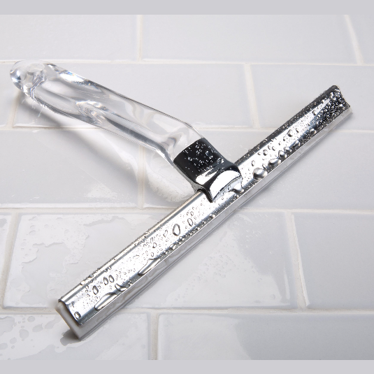 Clear-handled squeegee with metal blade and hook resting on wet white tile surface for home improvement use