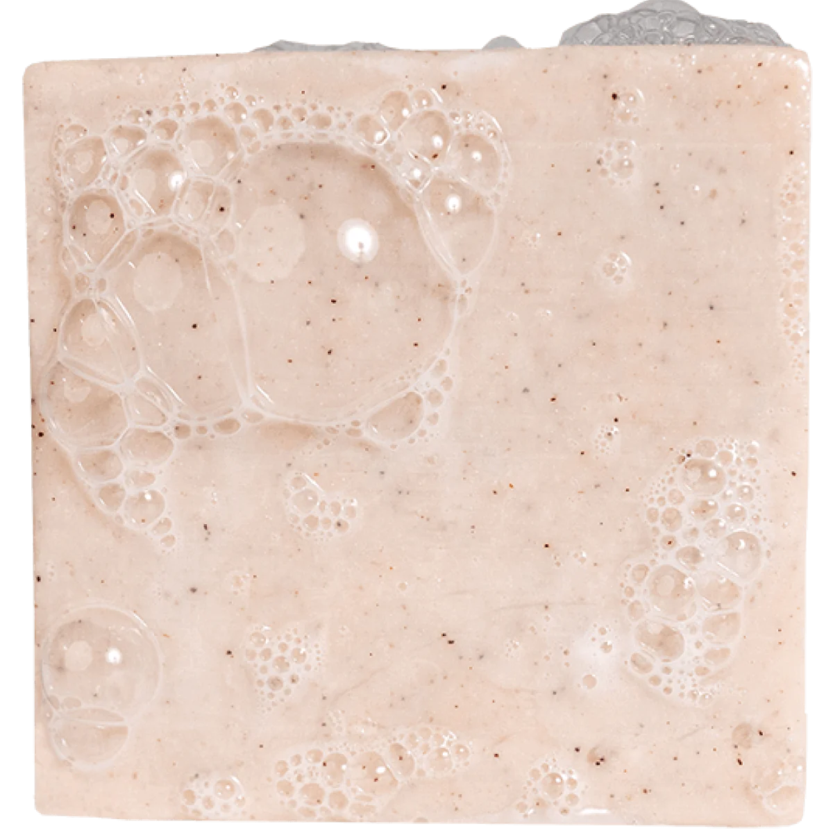 Light beige exfoliating soap bar with visible natural particles and gentle lather bubbles on surface