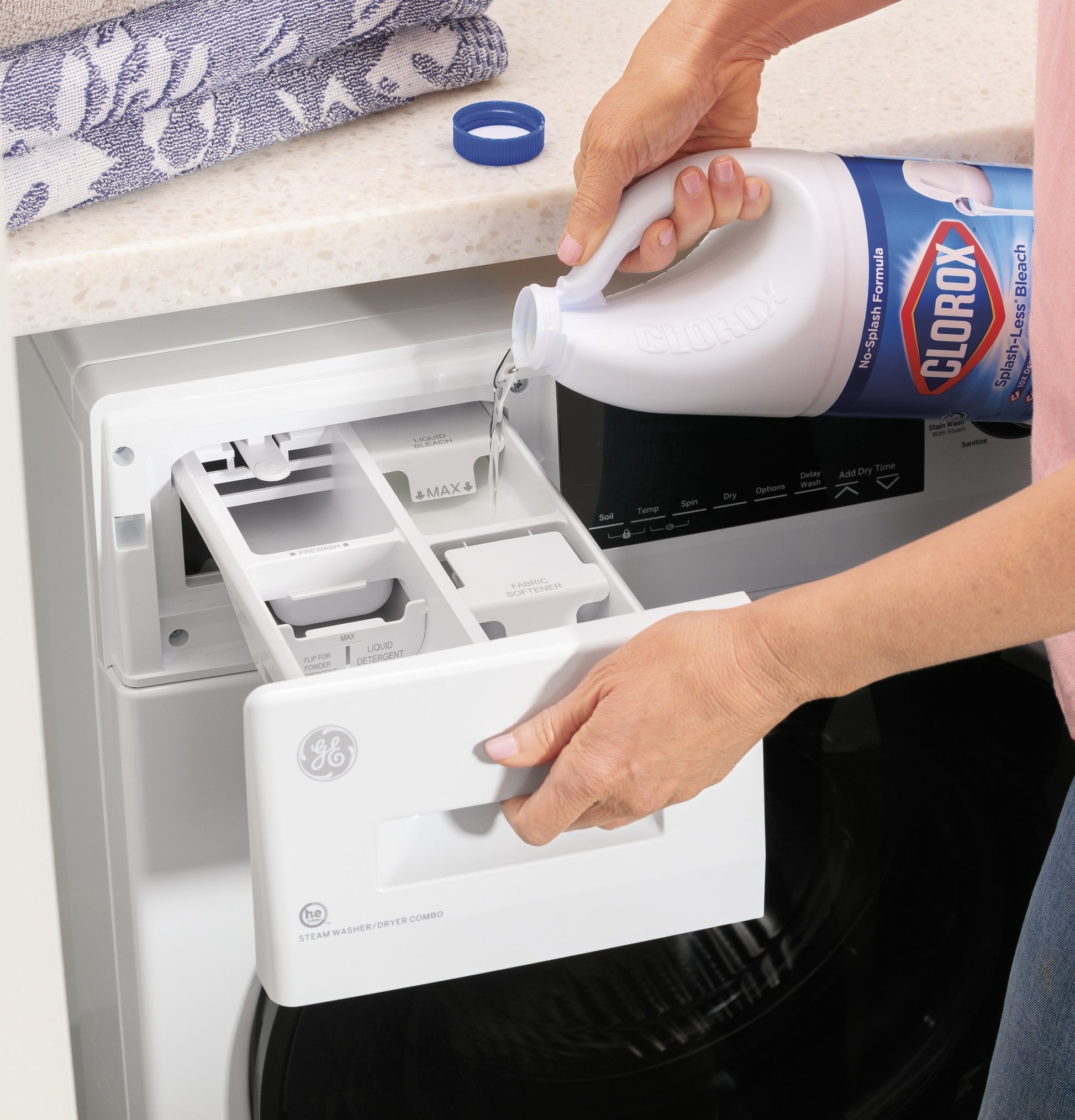 Person pouring liquid cleaner into detergent compartment of white front load washer from Washer/Dryer Combos collection
