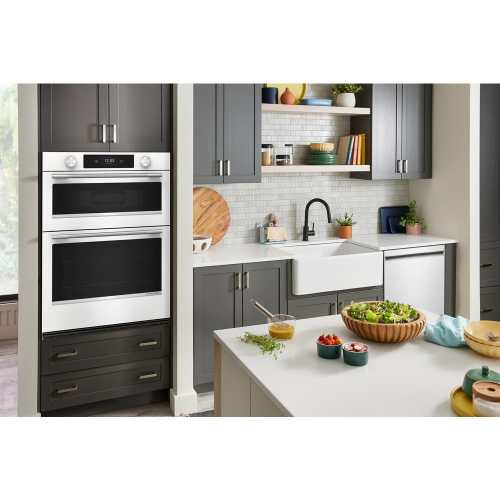 White 30-inch smart electric combo wall oven installed in modern kitchen with gray cabinets and farmhouse sink
