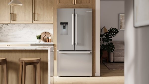Stainless steel French door refrigerator with bottom freezer and built-in water dispenser in modern kitchen setting