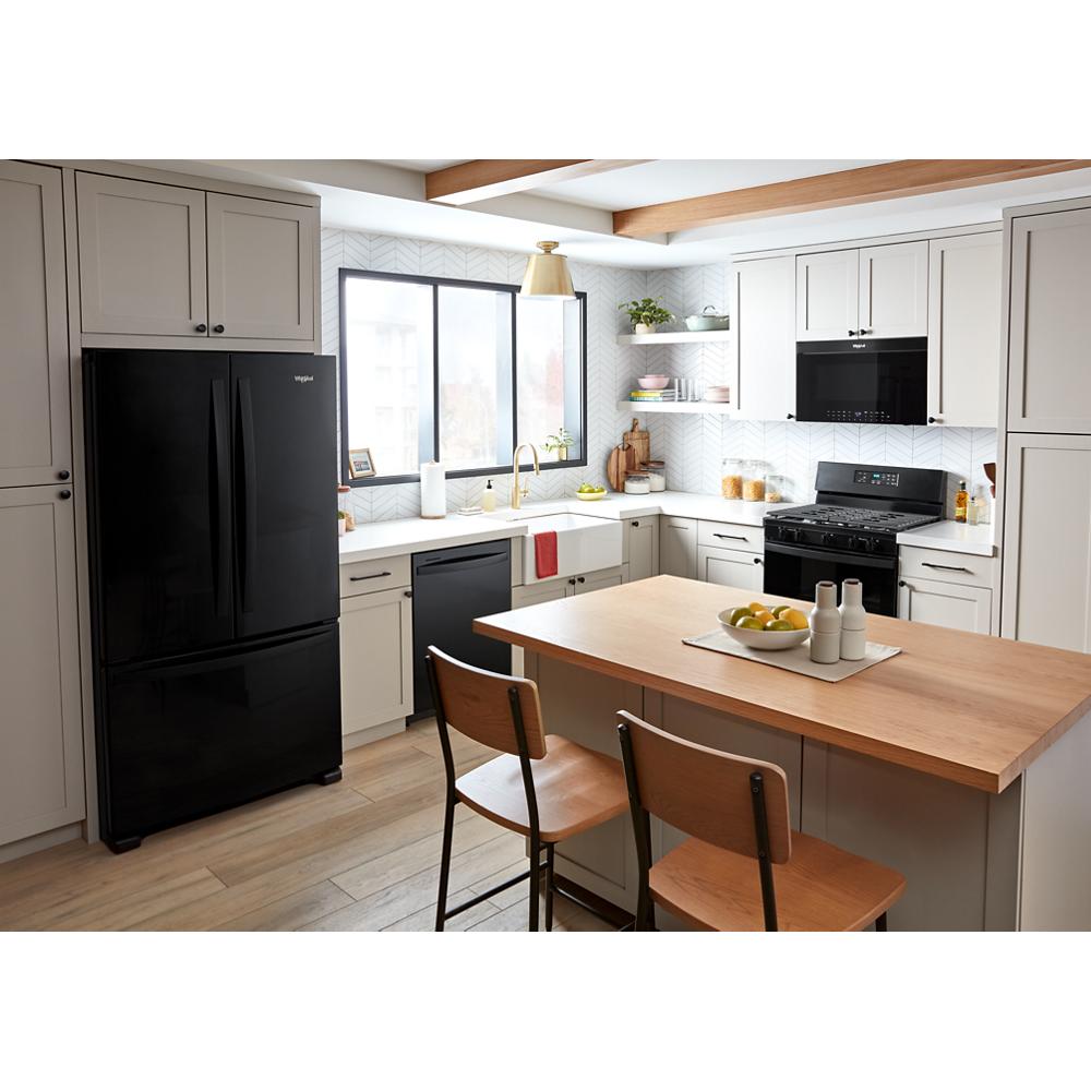 Bright kitchen with black refrigerator, built-in air fry microwave above black stove, white cabinetry, and wooden island seating