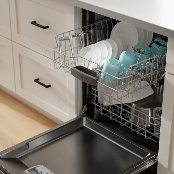 Open kitchen dishwasher with clean dishes and cookware inside a modern cabinet setting for home improvement