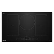 Black glass induction cooktop with five cooking zones and touch controls in KitchenAid appliances collection