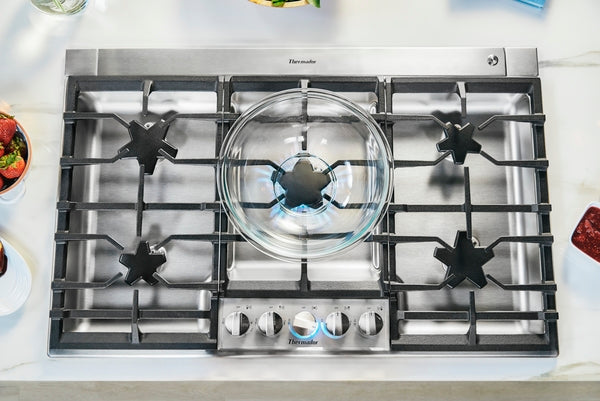 Overhead view of stainless steel 36-inch gas cooktop with five burners and central star burner from Thermador collection