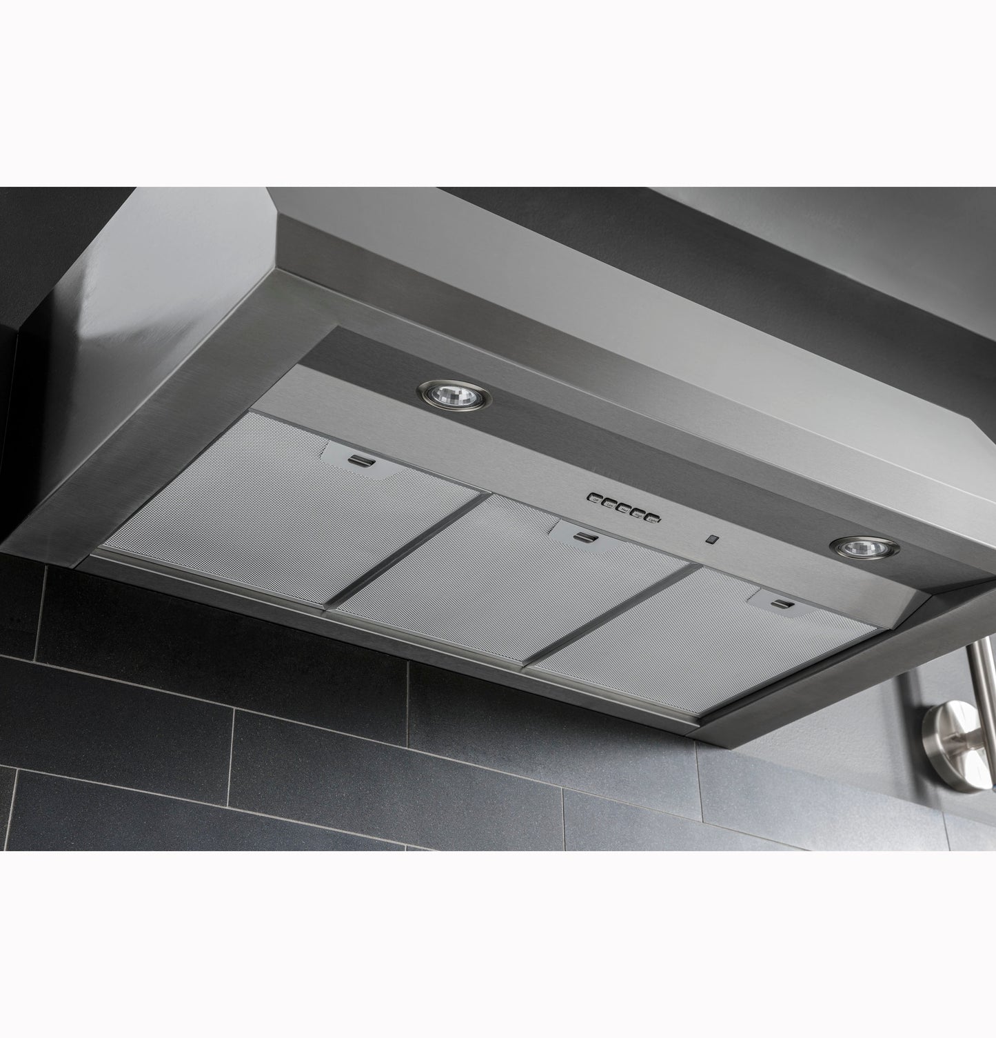 Stainless steel range hood with built-in lighting and control panel in modern kitchen and appliances collections