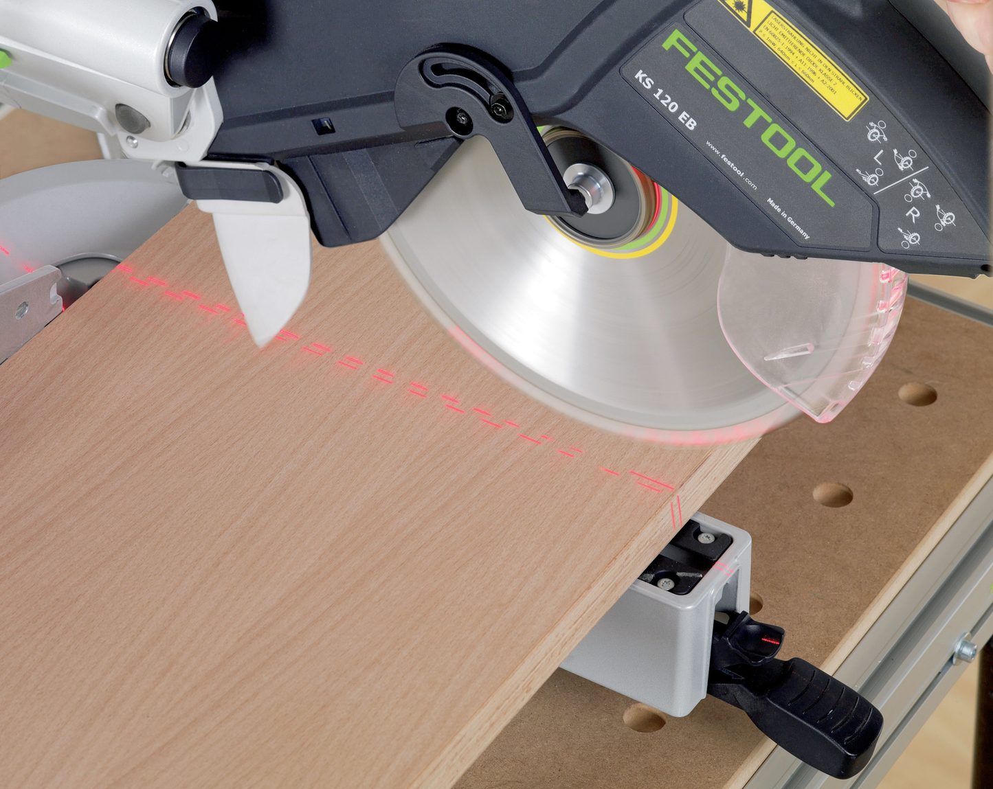 Festool sliding compound miter saw with laser guide making precise angled cut on wood in power tools collection