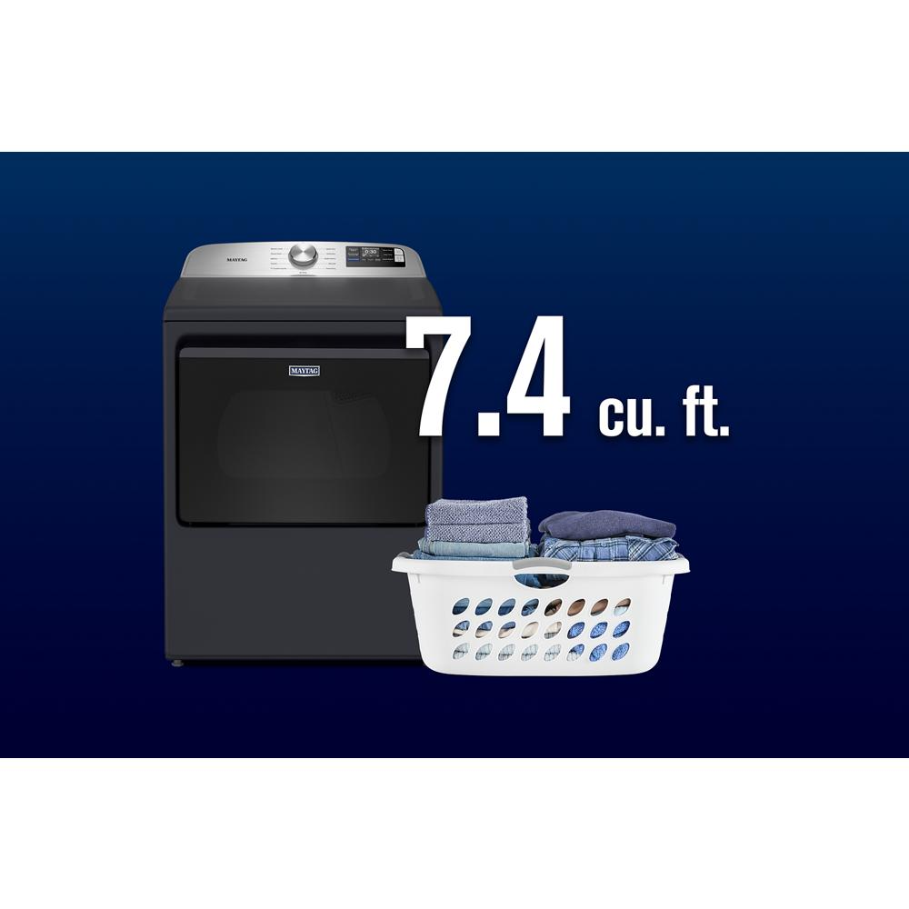 Dark gray top load gas dryer with digital panel next to laundry basket and large 7.4 cubic feet capacity label