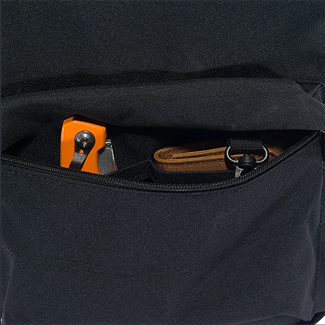 Front zippered pocket of black backpack holding orange multitool and brown leather keychain in bags and accessories collections