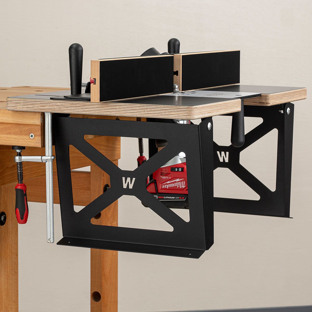 Close-up of wood and black metal router table system clamped to wooden workbench for woodworking tools collection