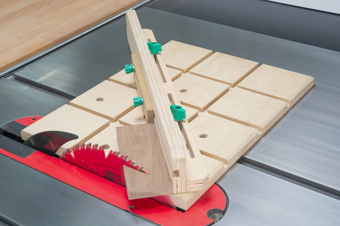 Adjustable wooden dovetail jig with green knobs set on a saw table, part of tool and saw accessories under $50