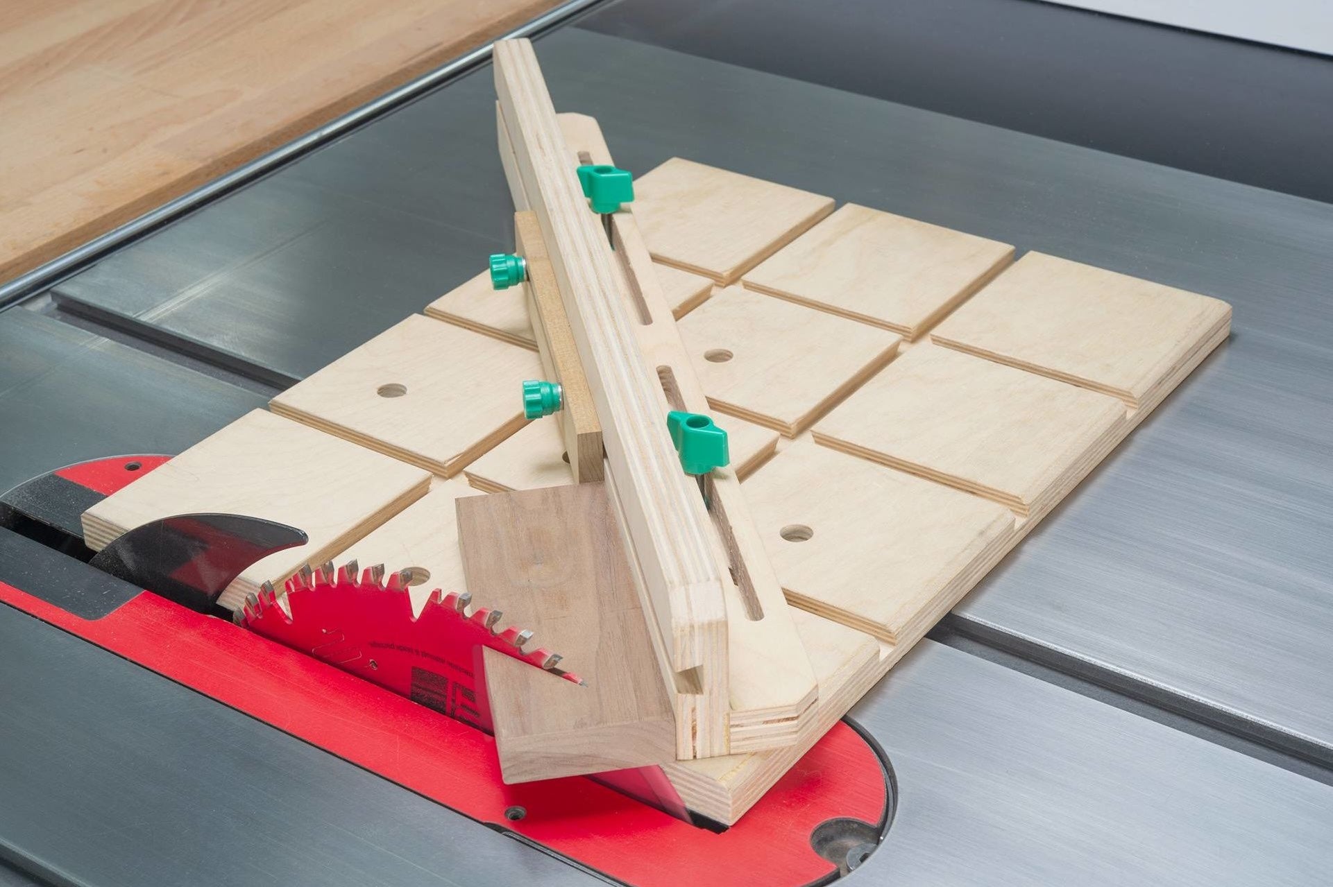 Adjustable wooden dovetail jig with green knobs set on a saw table, part of tool and saw accessories under $50