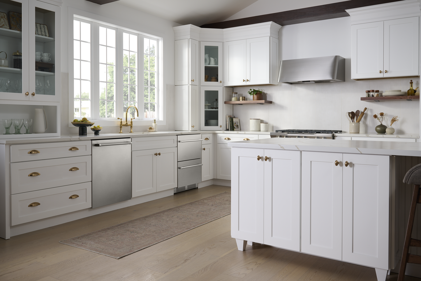 Modern kitchen with white cabinetry, wooden flooring, stainless steel under-counter refrigerator drawers, and large windows