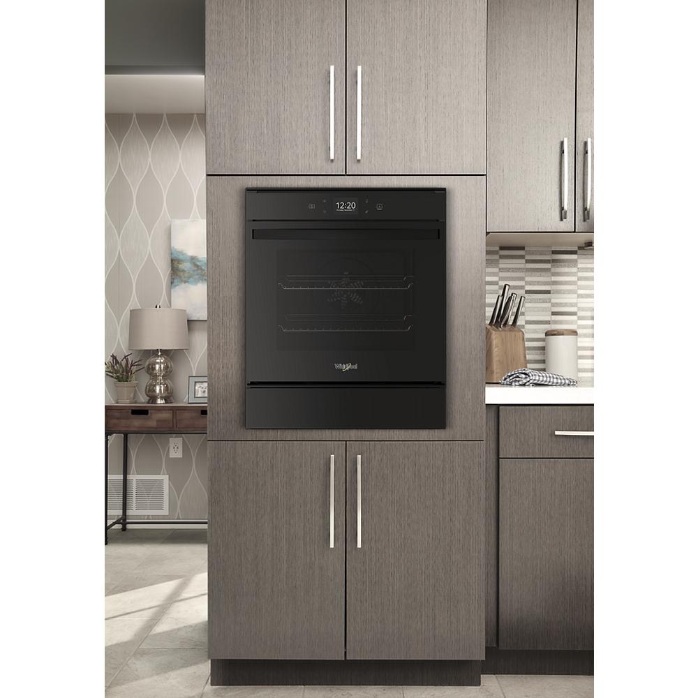 Built-in black convection wall oven integrated into modern gray kitchen cabinets in home improvement setting