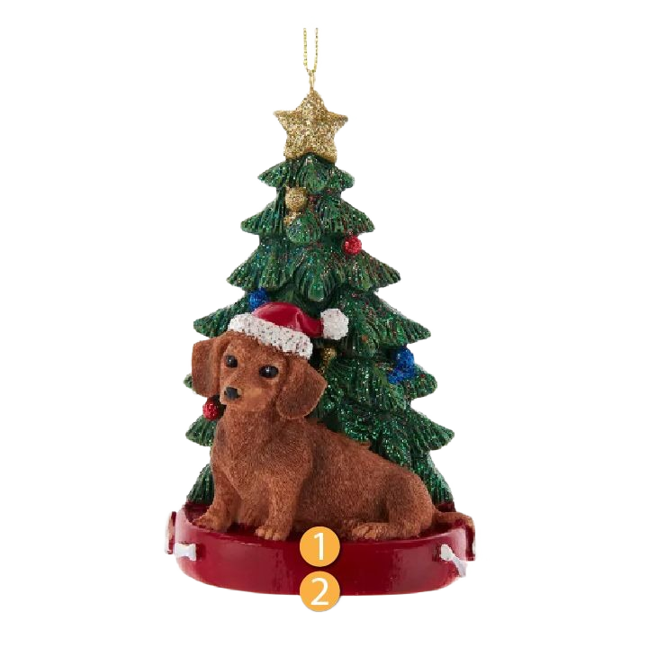 Brown dachshund figurine wearing Santa hat sitting in front of decorated green Christmas tree with gold star topper