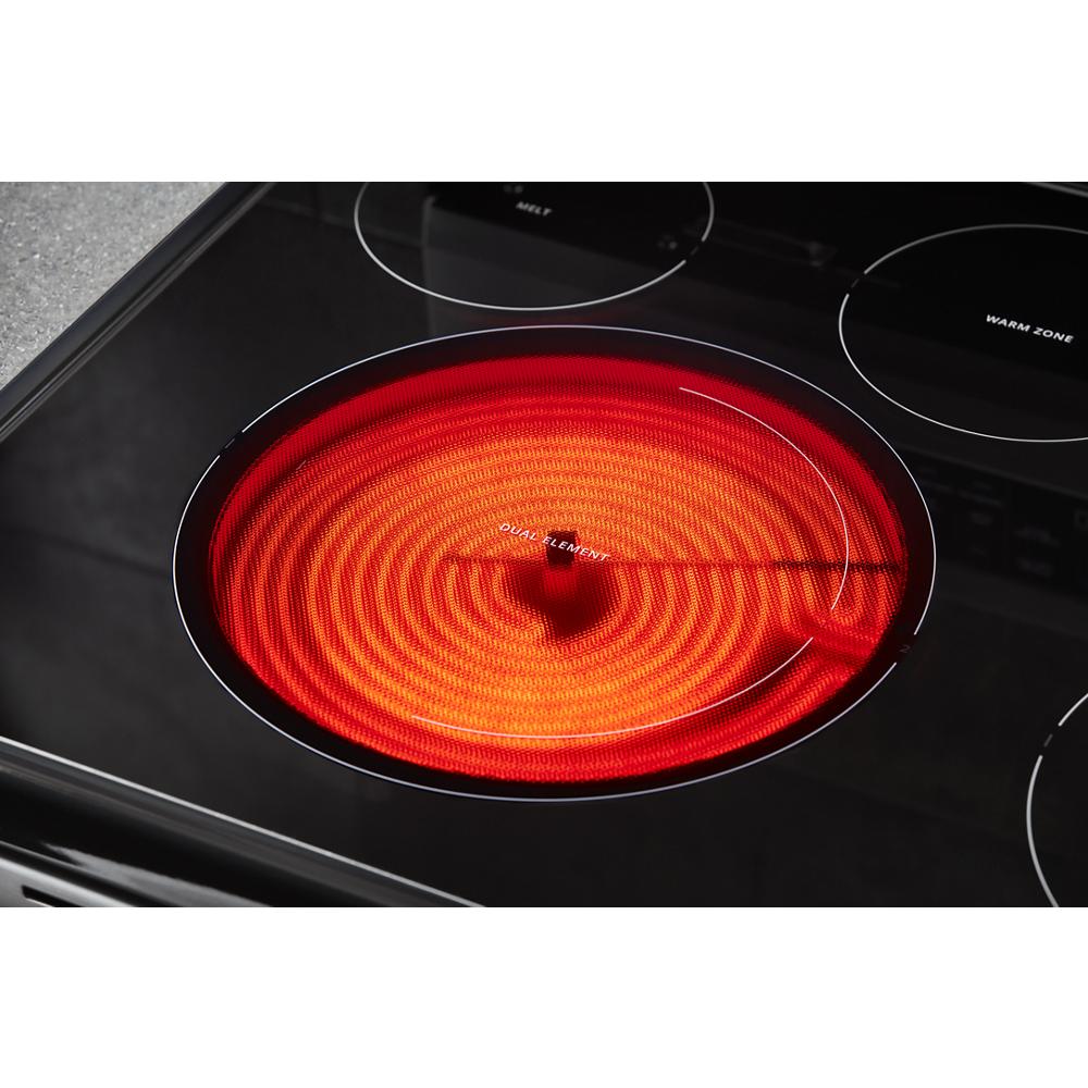 close-up of glowing electric range heating element on black cooktop for kitchen and home improvement