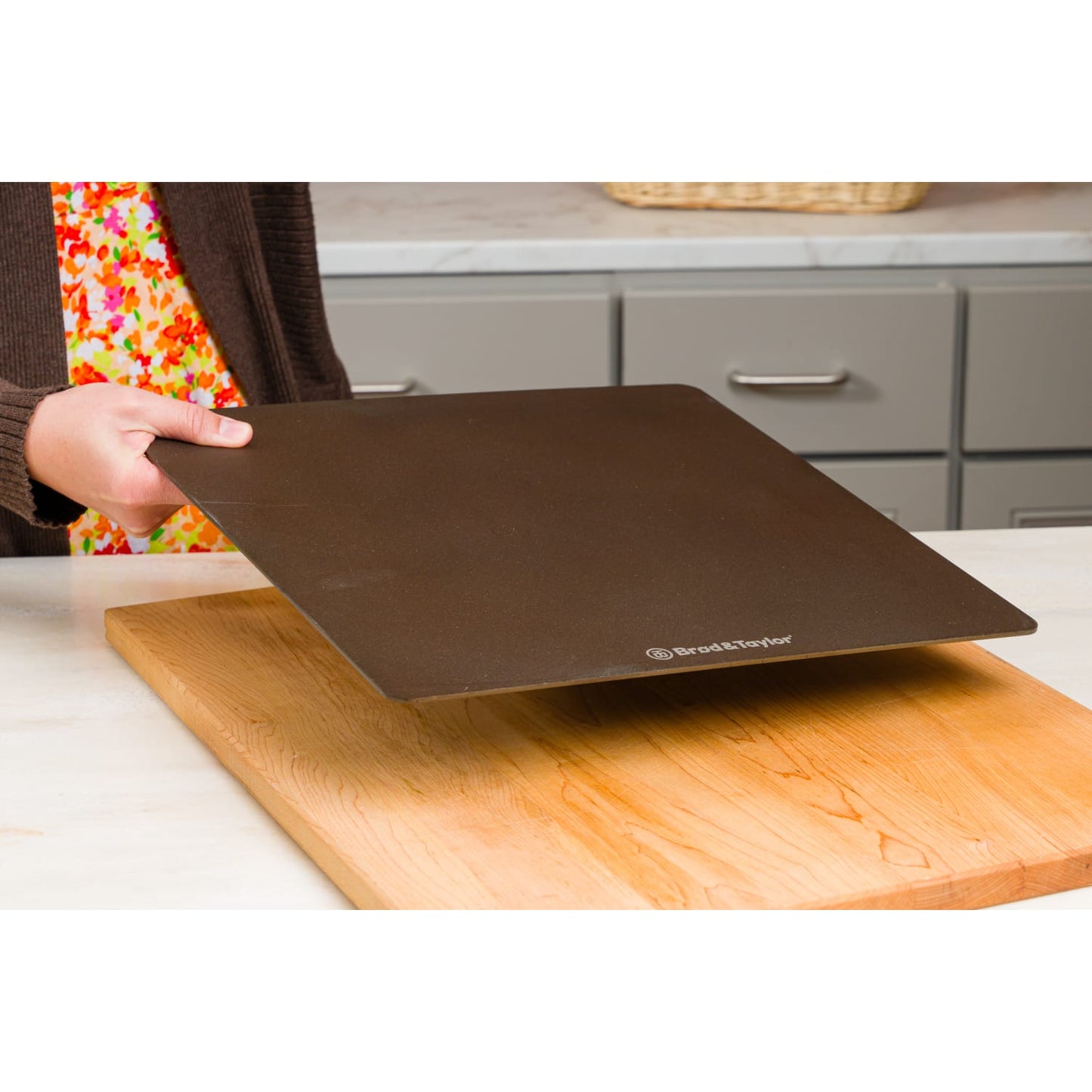 Hand holding Brod & Taylor Bread Steel above wooden cutting board in modern kitchen setting from kitchenware collection
