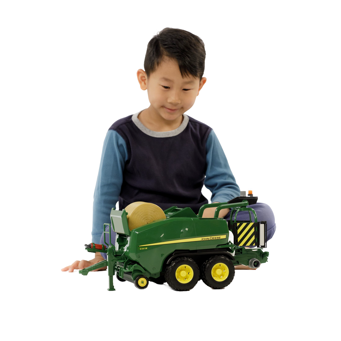 Child playing with green and yellow toy baler in Bruder Toys from Vehicles & Remote Controlled Toys collection
