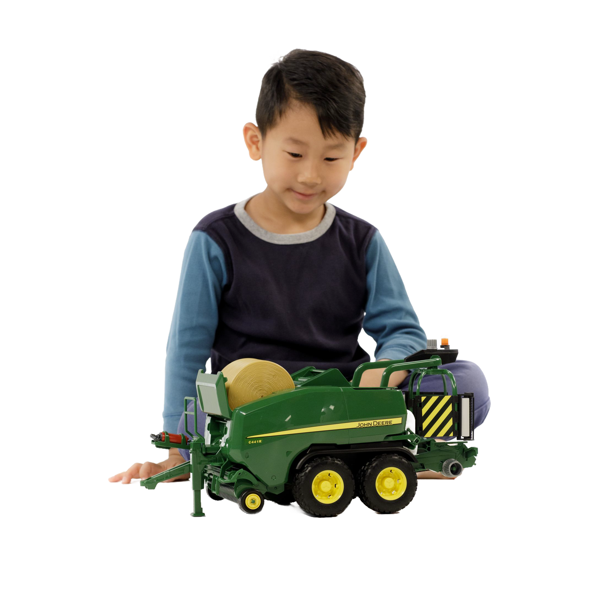 Child playing with green and yellow toy baler in Bruder Toys from Vehicles & Remote Controlled Toys collection