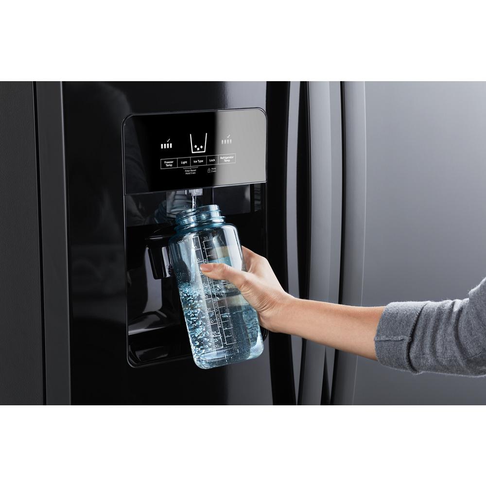 Hand filling a clear water bottle at the built-in dispenser of a black side-by-side refrigerator, part of Kitchen & Kitchenware and Appliances collections.