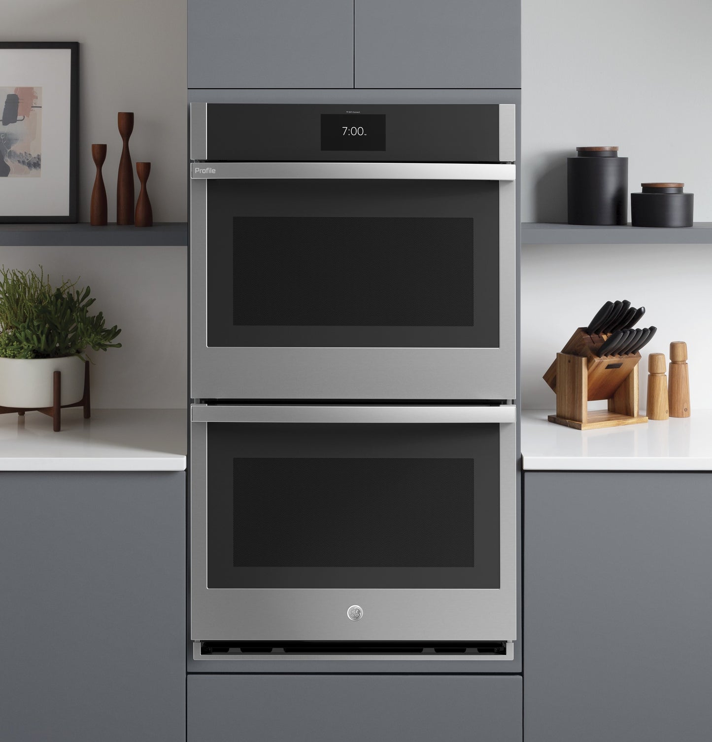 Built-in stainless steel double wall oven installed in modern kitchen with gray cabinetry and white countertops