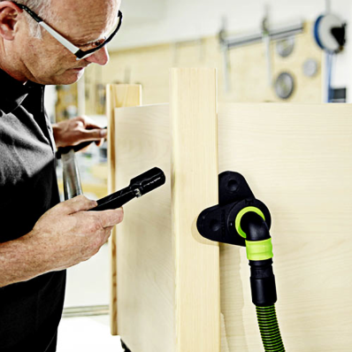 Woodworker using Festool CT Wings accessory with vacuum hose for dust management in a workshop setting
