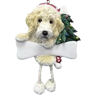 Cream-colored Labradoodle dog ornament with dangling legs holding blank sign and Christmas tree decoration