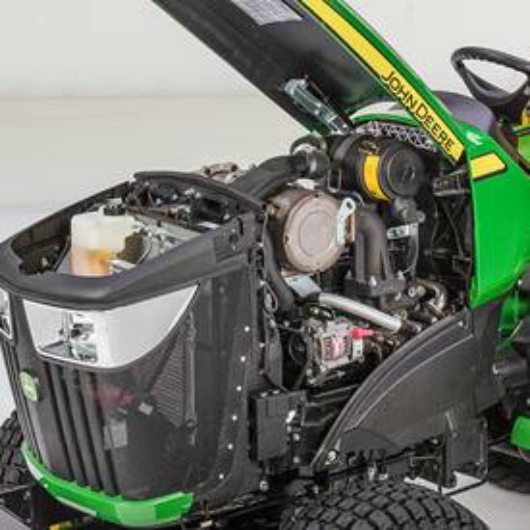Close-up of engine and internal components on green and yellow John Deere 3038E compact tractor with open hood