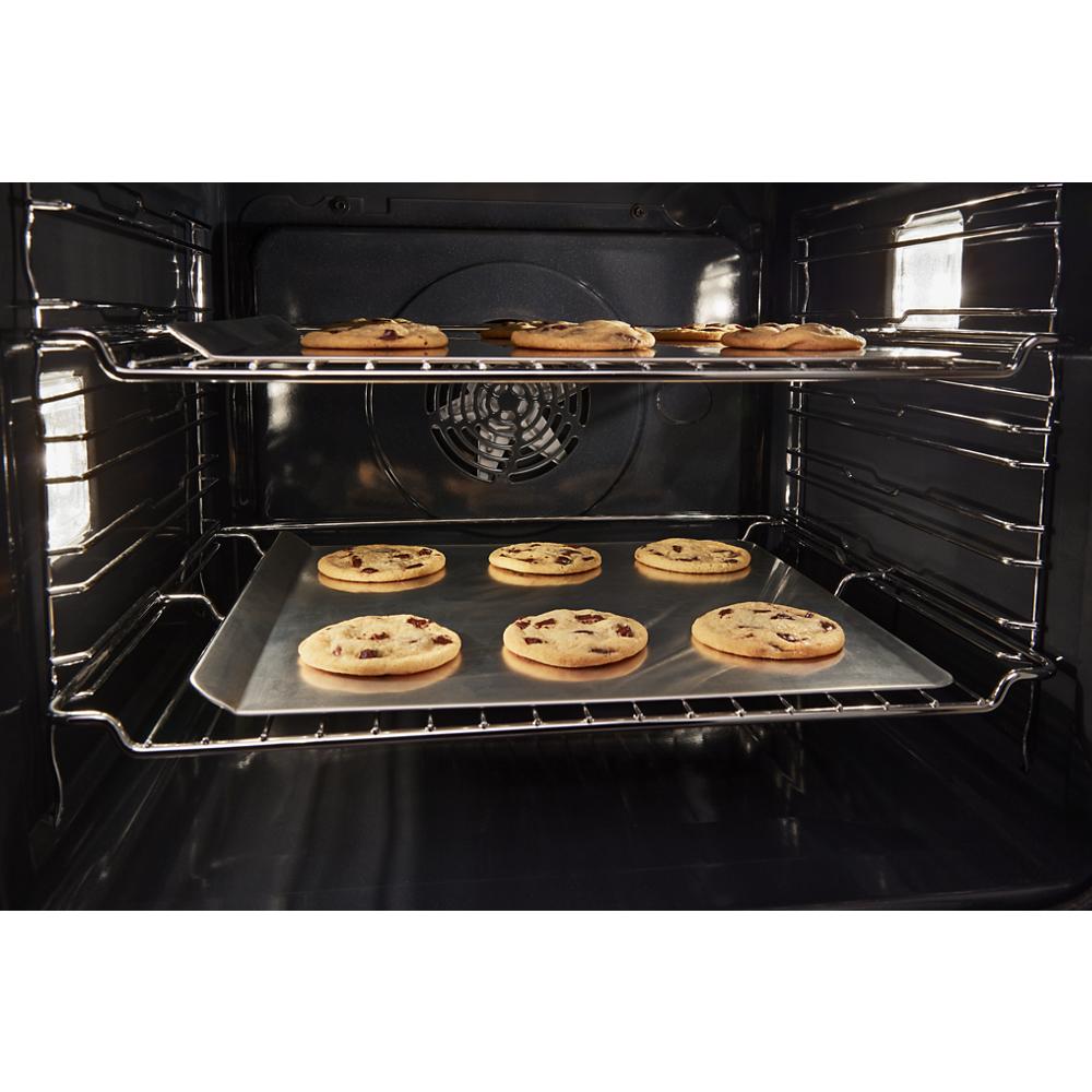 Chocolate chip cookies baking on racks inside a 24 inch double wall oven with convection from kitchen appliances collection