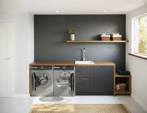 Laundry room featuring Bosch front load pearl steel washer and dryer with wooden countertops and dark cabinetry