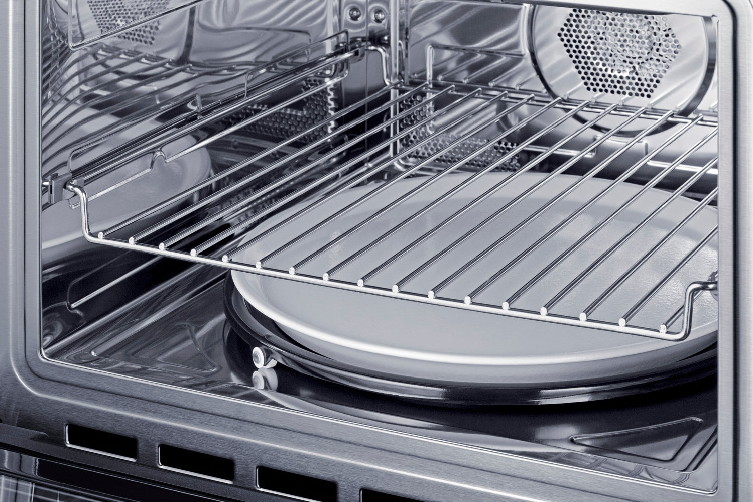 Interior view of a stainless steel speed oven featuring a removable wire rack and glass turntable plate in appliances collection