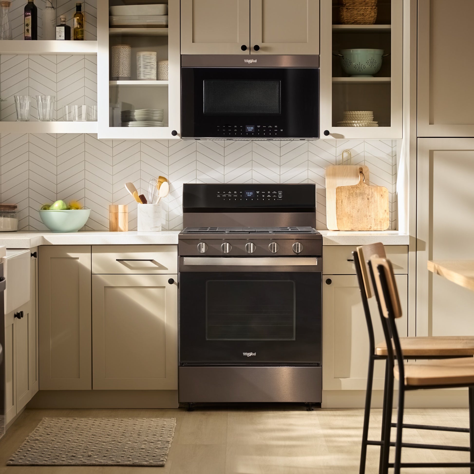 Black built-in air fry microwave installed above matching modern freestanding oven in neutral-toned kitchen setting