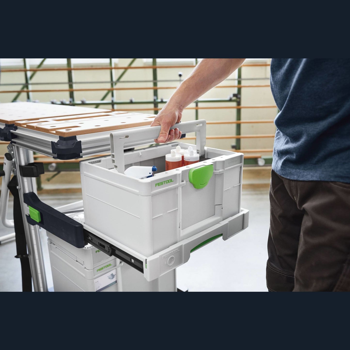 White and green modular Festool tool storage box with handle on a sliding workshop organizer system