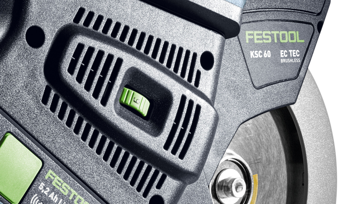 Close-up of Festool cordless compound miter saw motor housing and blade guard, featuring power switch and branding.