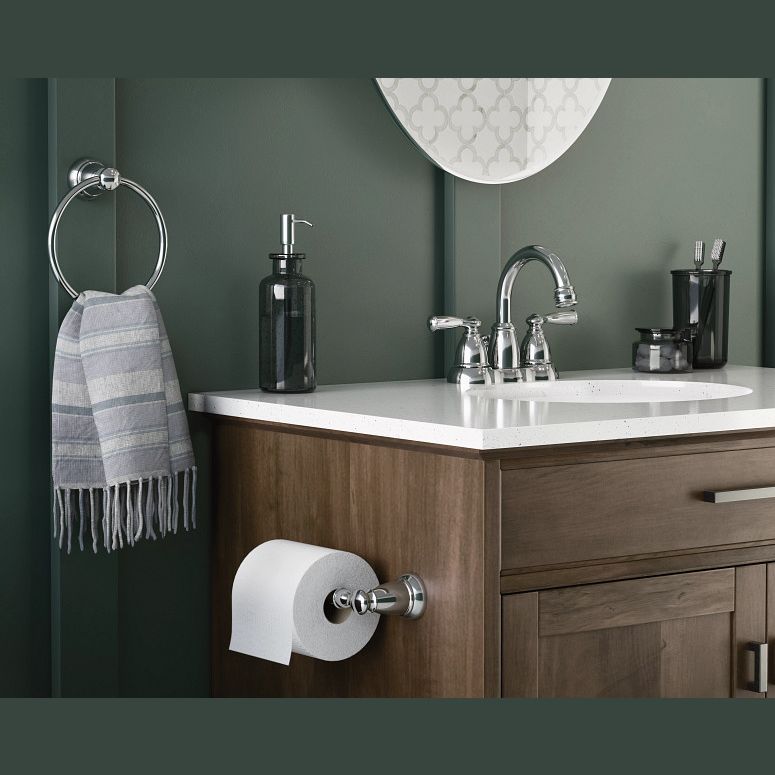 Chrome towel ring mounted on green wall next to wooden vanity with white countertop for bathroom decor and home improvement