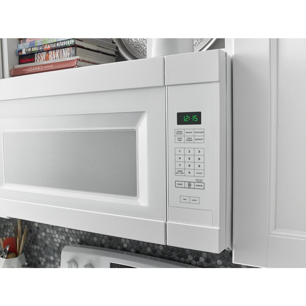 White over-the-range microwave with digital keypad and clock in modern kitchen from kitchen appliances collection
