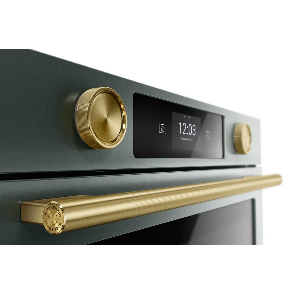 Close-up of juniper smart electric wall oven with gold-tone handle and knobs, LED touchscreen in KitchenAid Appliances collection